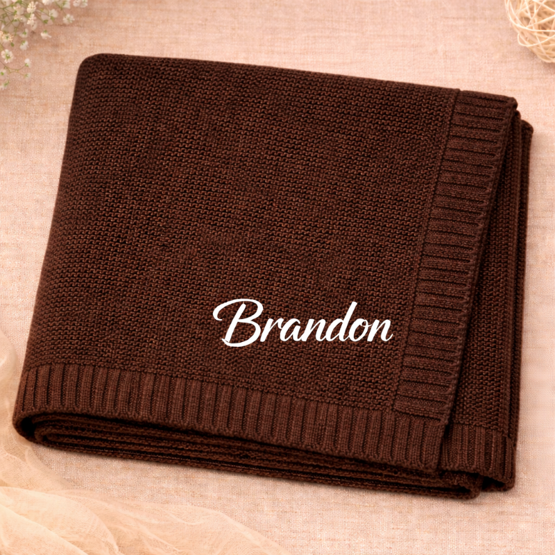 Kaffeebraune gestrickte Babydecke mit weißen Buchstaben