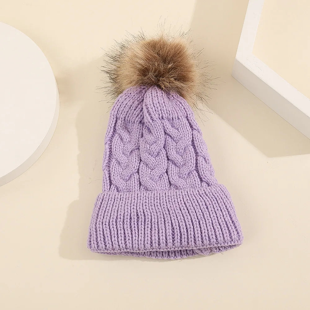 Lila Babymütze mit Bommel