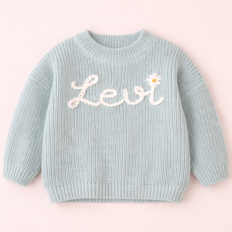 Hellblauer Babypullover mit dem Namen Levi und einer Margerite