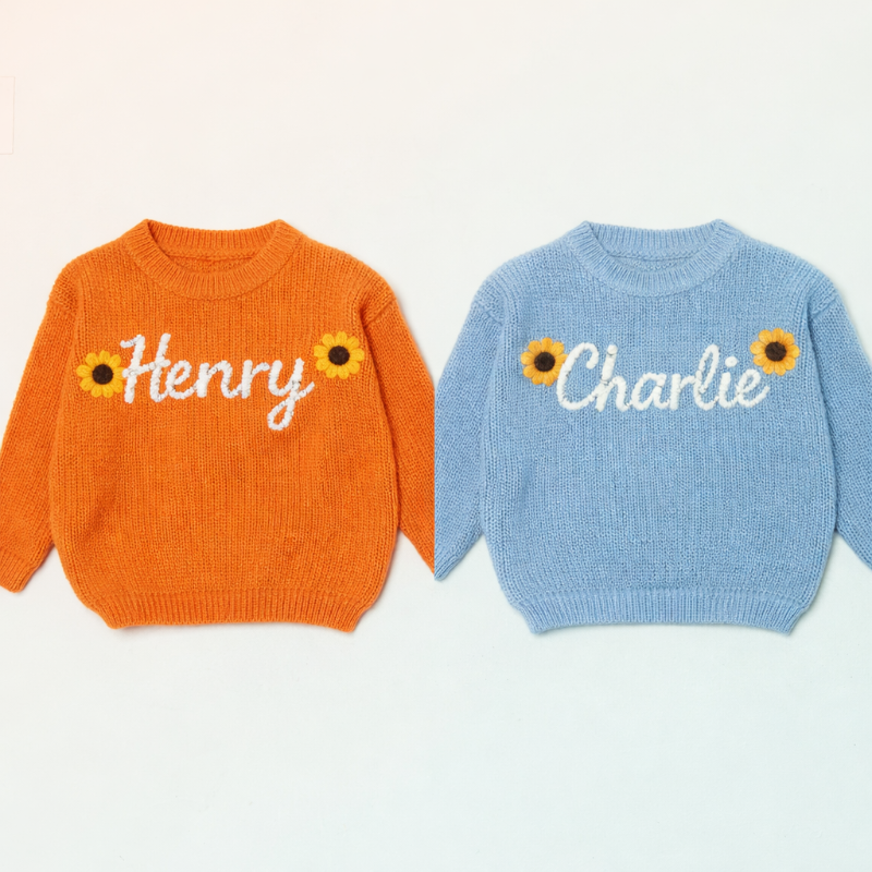 Oranger und hellblauer Babypullover mit Sonnenblumen und den Namen Henry und Charlie