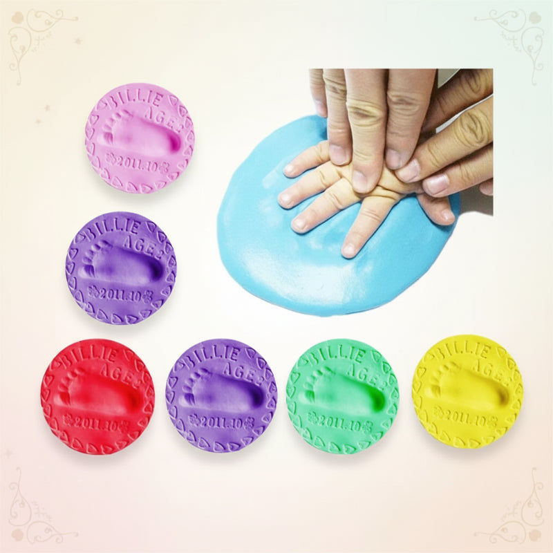 Babyhand wird in den Ton gedrückt, um einen Abdruck zu machen