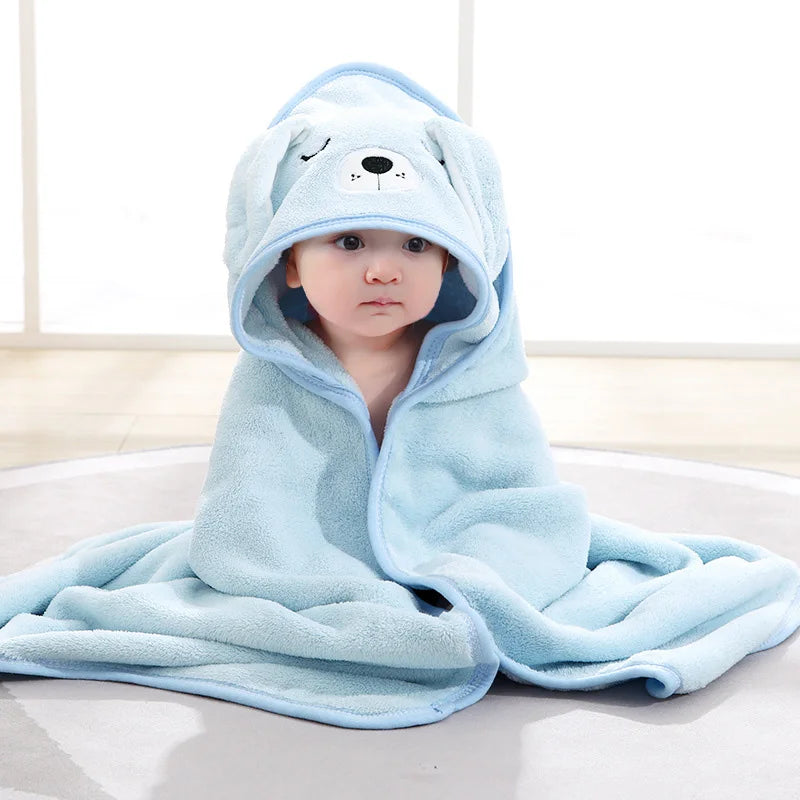 Baby im blauen Kapuzenhandtuch in Form eines Hundes