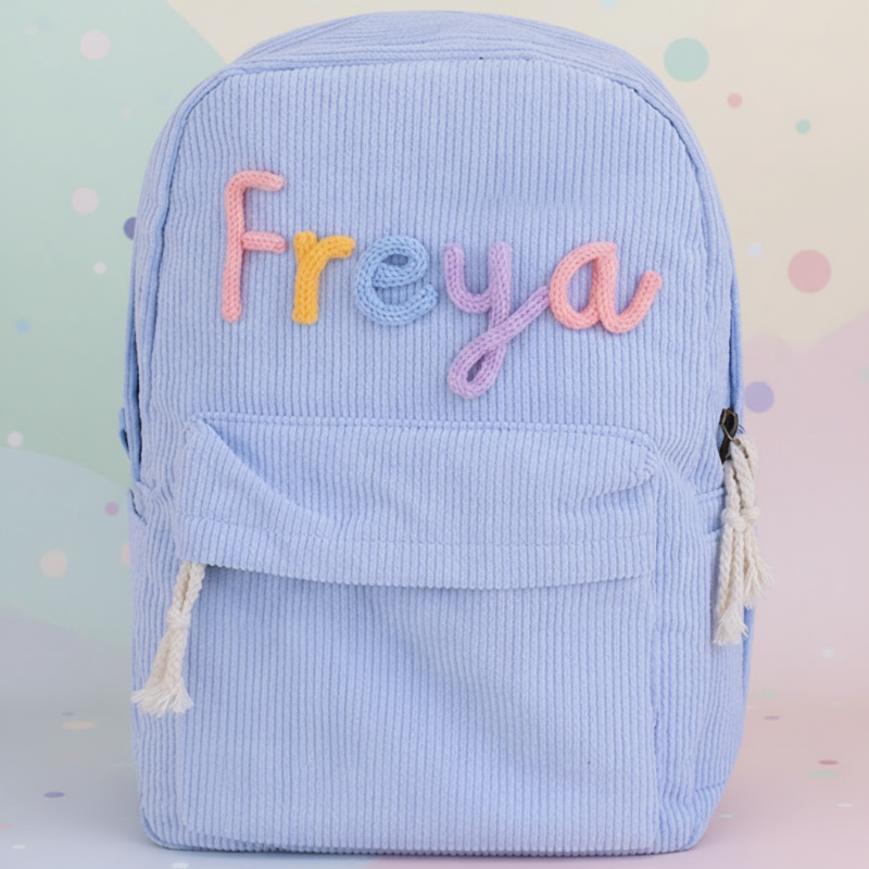Blauer Cord-Rucksack mit einem Namen in bunten Buchstaben