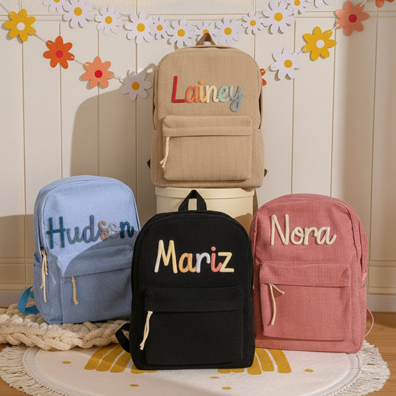 Vier personalisierte Kinderrucksäcke nebeneinander in verschiedenen Farben