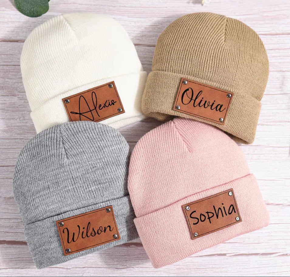 Vier gestrickte Beanies mit Namenspatches mit den Namen Alexis, Olivia, Wilson und Sophia
