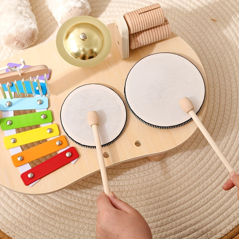 Zwei Hände spielen die Trommeln des Musiktischs mit den Schlägeln
