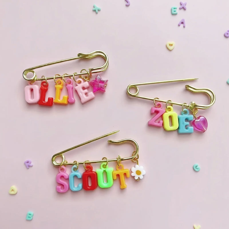 Drei Namensanstecker mit Buchstabenperlen und Anhängern
