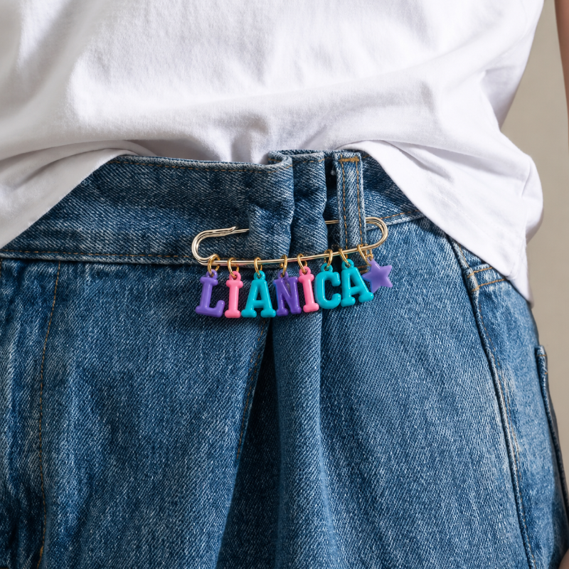 Namensanstecker mit Buchstabenperlen an einer Jeans getragen
