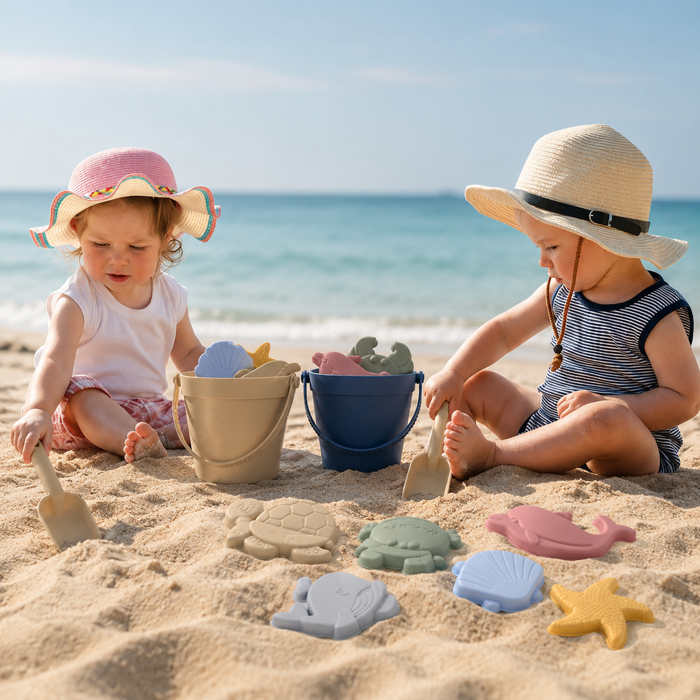 Zwei Kinder spielen am Strand mit dem Sandspielzeug aus Silikon