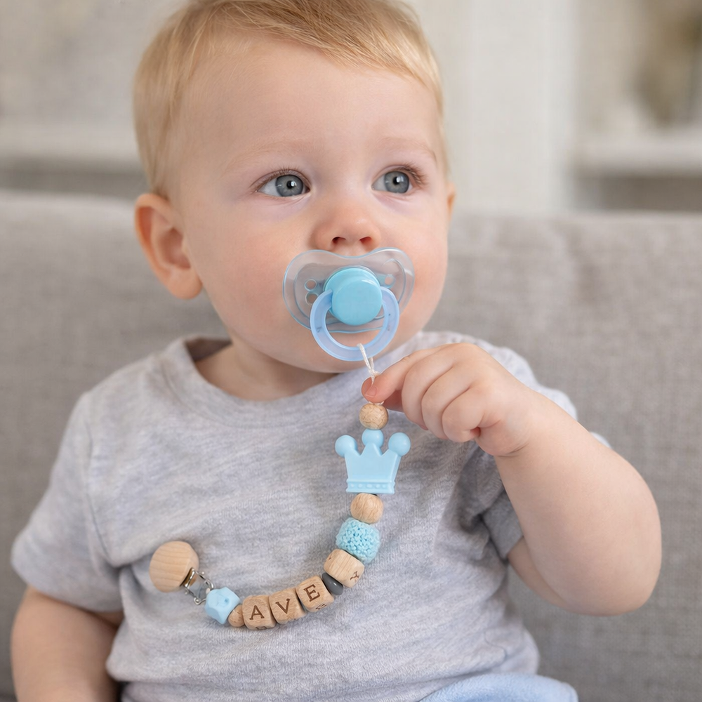 Baby mit Schnuller an der personalisierten Schnullerkette mit Namen
