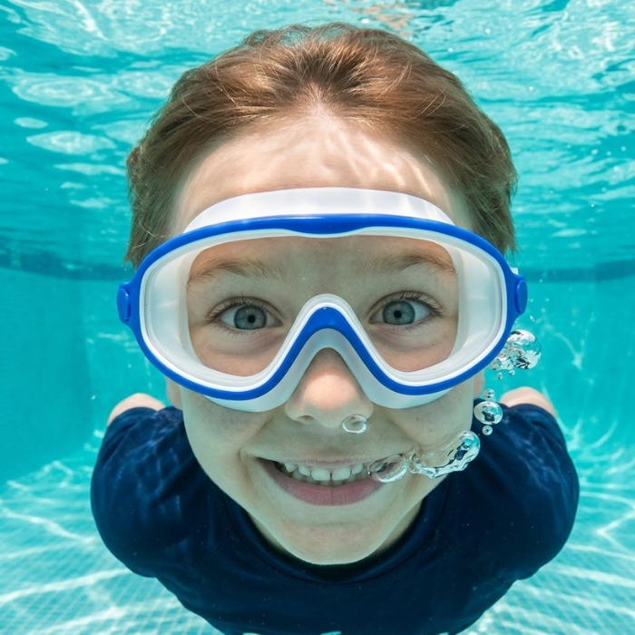 Kind schwimmt mit der Schwimmbrille unter Wasser