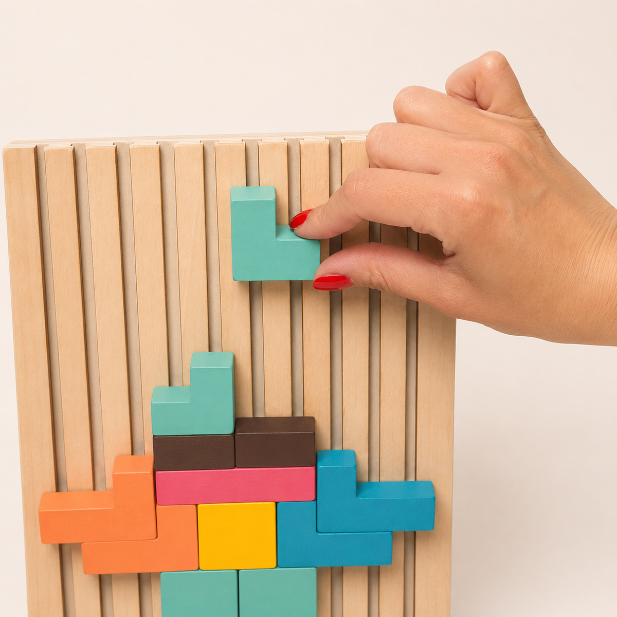 Hand schiebt einen Klotz in das senkrechte Puzzlebrett