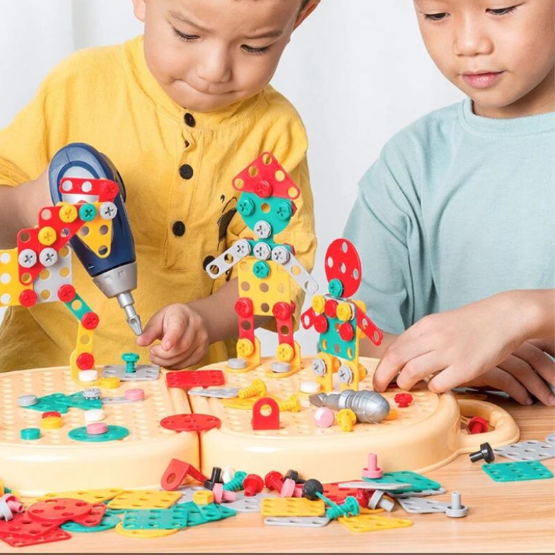 Zwei Kinder bauen gemeinsam mit dem Werkzeugkoffer und der Bohrmaschine